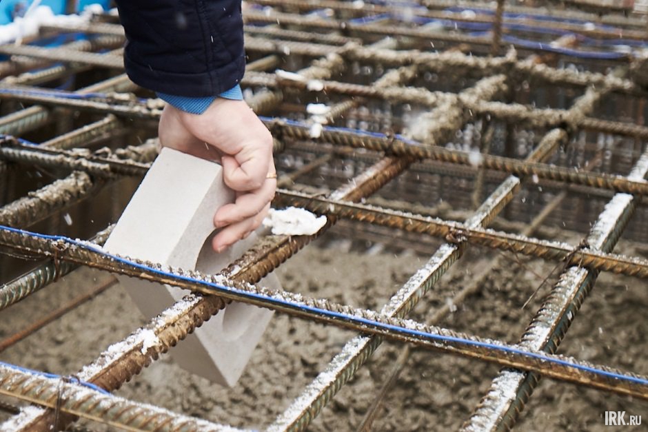 Погружение символичного кирпича в фундамент. Фото Маргариты Романовой, IRK.ru