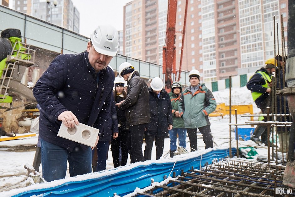 Погружение символичного кирпича в фундамент. Фото Маргариты Романовой, IRK.ru