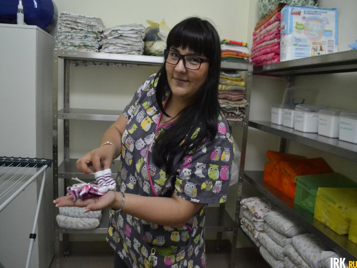 Врач-неонатолог Ольга Федорова демонстрирует одежду для малышей