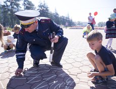 Участники нарисовали мелом на асфальте большую ромашку — символ жизни на дороге, внимания друг к другу и хрупкости жизни.
