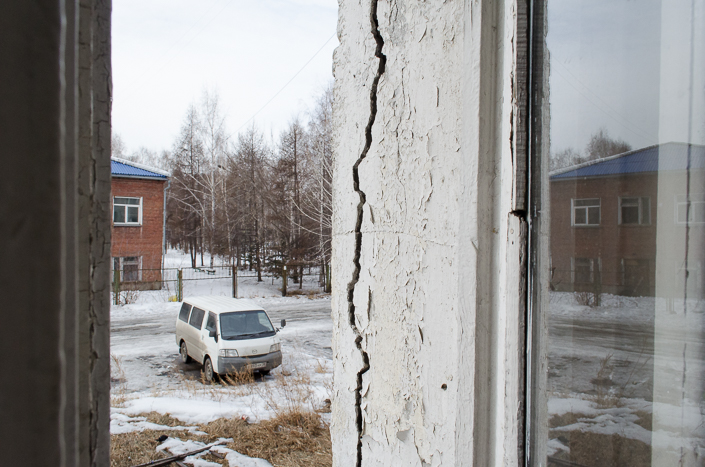 По стенам здания змеятся трещины. Жители опасаются, что здание рухнет, как карточный домик.