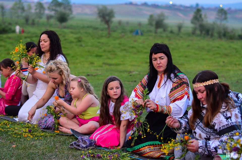 Собрав цветы, девушки рассаживаются вокруг шеста и под песни плетут венки.