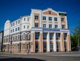 Здесь же через дорогу находится бывшее Иркутское высшее начальное Александро-Мариинское училище. Здание построено в 1895 году. Верхние два этажа надстроены в 1930 году.