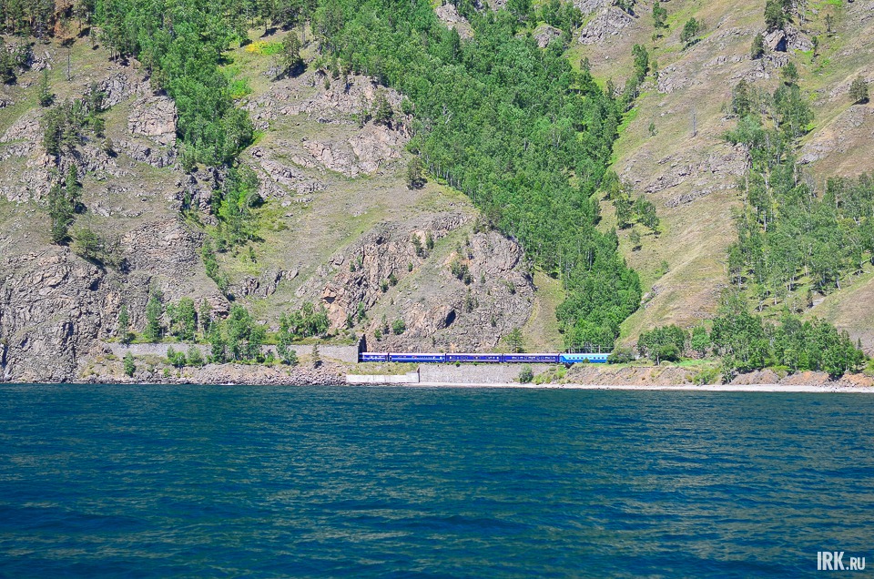 Вдали виднеются туристический поезд и тоннели.