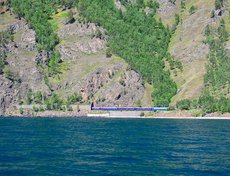 Вдали виднеются туристический поезд и тоннели.
