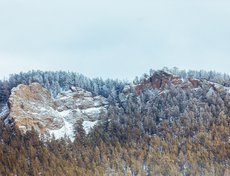 Вид из беседки на заснеженные скалы впечатляет.