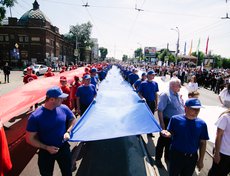 После митинга колонна волонтёров пронесла по улице Ленина 50-метровые полотна цветов российского флага.