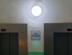 Внутри административного здания работают лифты для сотрудников. На табличке показатель высоты каждого этажа над уровнем моря по тихоокеанской системе высот.