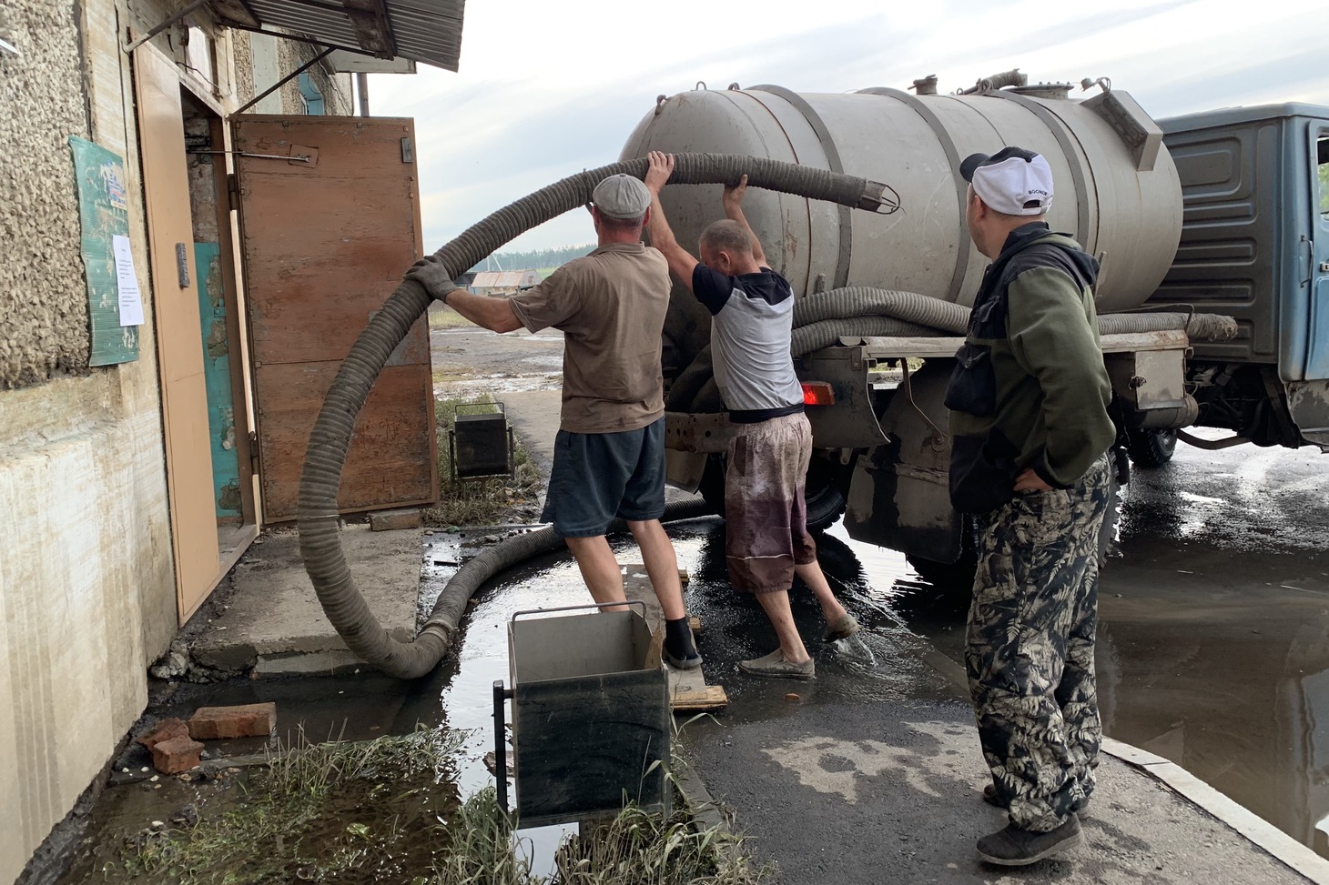 Рабочие выкачивают воду из подвала в «Рабочем городке»