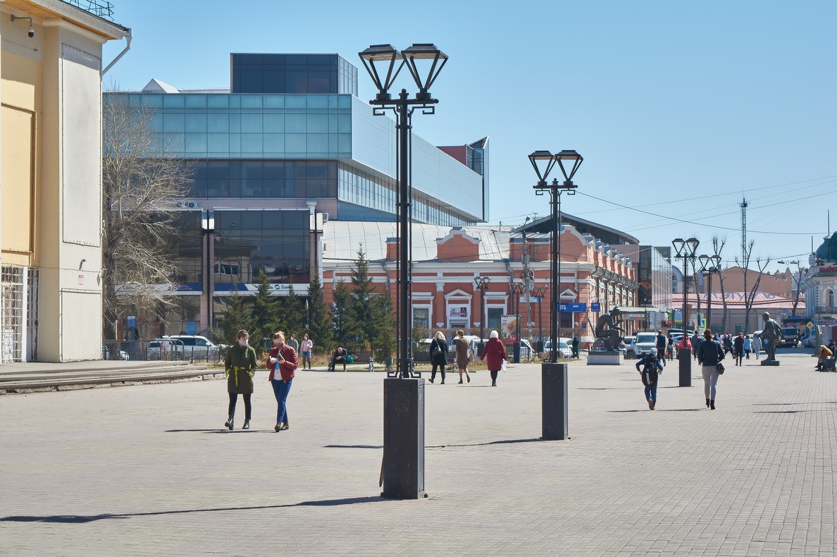 На площади у цирка людно. Горожане идут по своим делам, стараясь обходить фотографа.