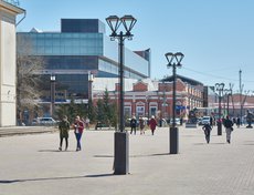 На площади у цирка людно. Горожане идут по своим делам, стараясь обходить фотографа.