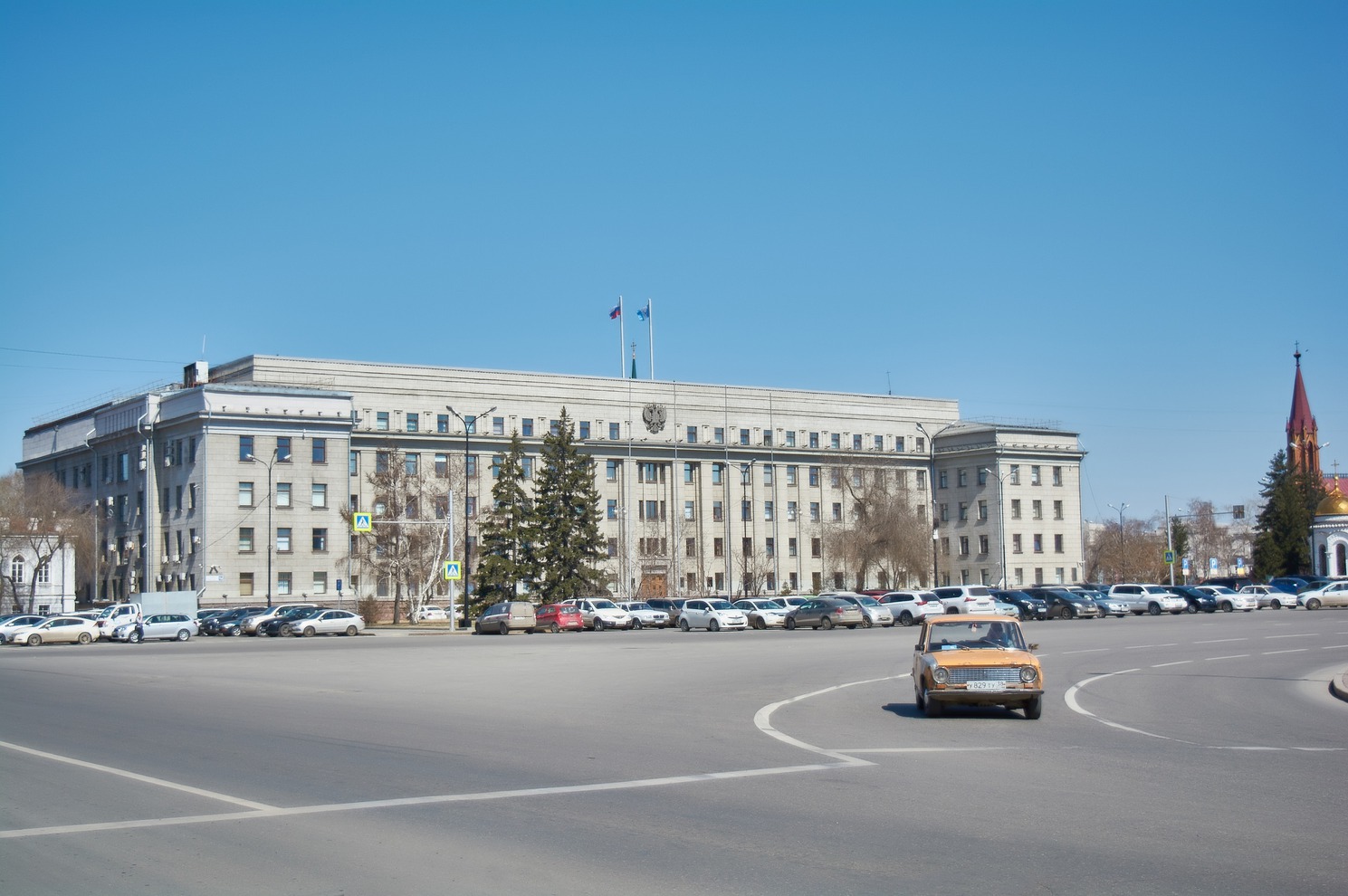 В будний день парковка у здания правительства не пустует.