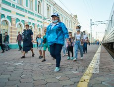 Волонтёр ведёт очередную группу в хвостовой вагон, к началу экскурсии.