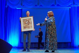 Наталья Варлей передает портрет Гайдая. Фото Иркутского областного кинофонда