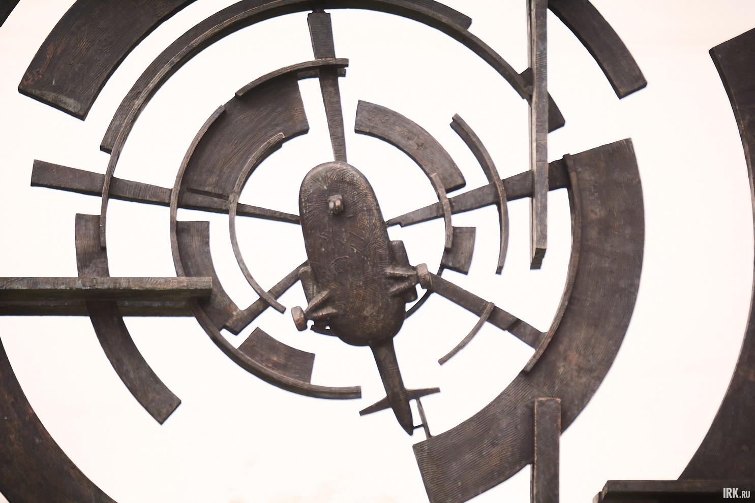 В верхней части памятника размещён вертолёт, вокруг которого ореол, олицетворяющий воздушные массы от его несущего винта.