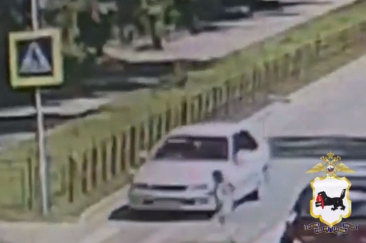 Девочка бежит по пешеходному переходу перед машиной. Скриншот видео ГУ МВД России по Иркутской области