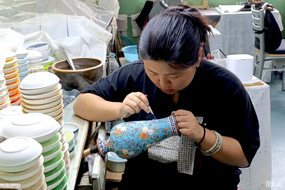 Мастер красит вазу