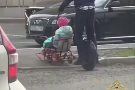 Мужчина ехал на моноколесе и одновременно вез ребенка на санках. Скриншот видео из телеграм-канала ГУ МВД по региону