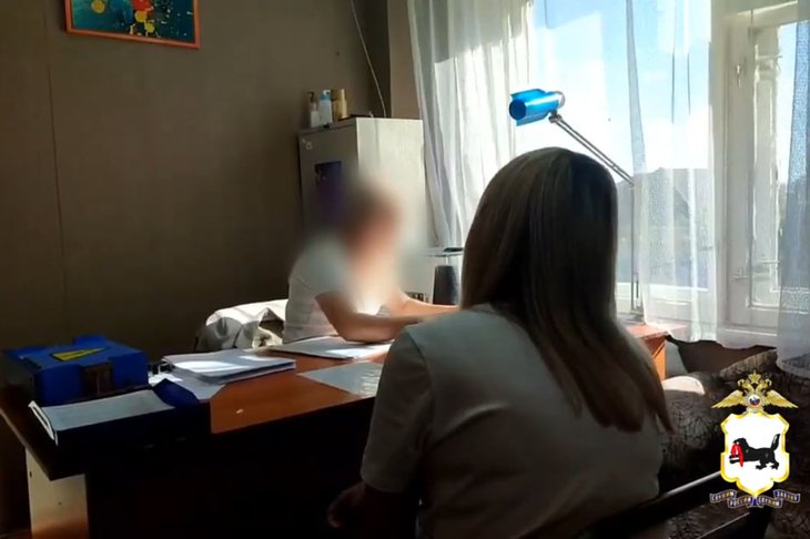 Задержанная за мошенничество женщина и полицейский. Скриншот видео пресс-службы ГУ МВД России по Иркутской области
