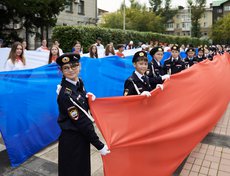 В завершении праздника волонтёры развернули бело-сине-красное полотнище длиной 25 метров.