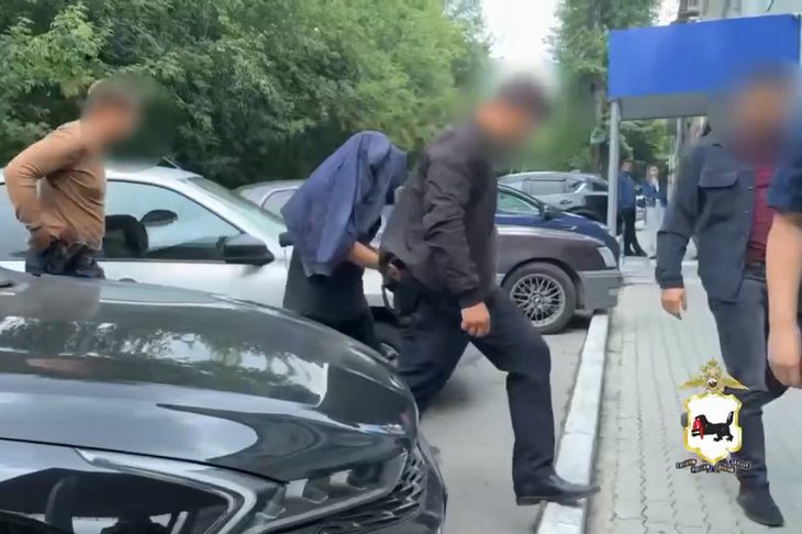 Правоохранители с фигурантом. Скриншот видео пресс-службы ГУ МВД России по Иркутской области