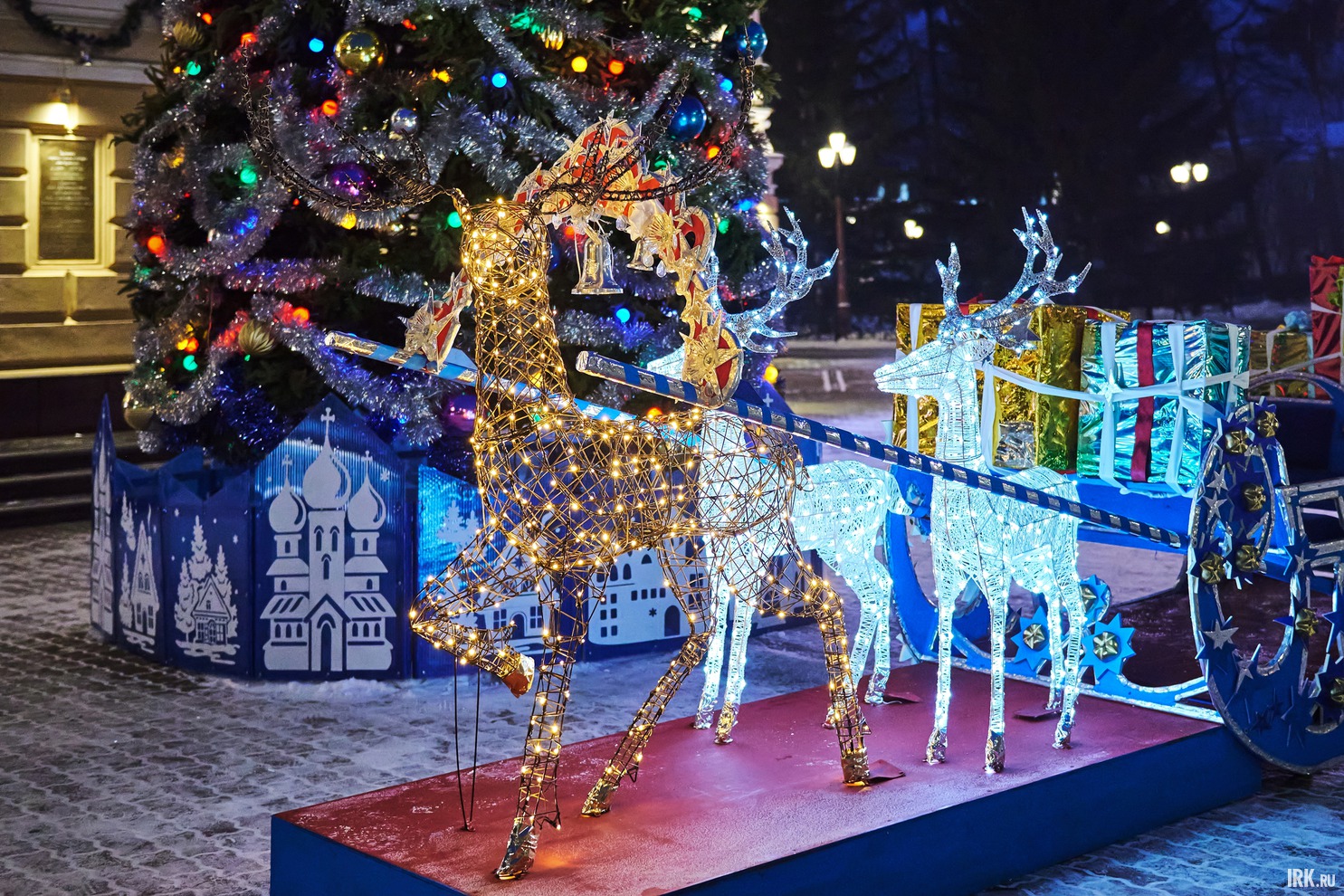 Перед театром стоят сани, запряжённые оленями.