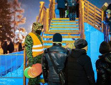 У лестницы на горку дежурят волонтёры, которые контролируют поток желающих покататься.