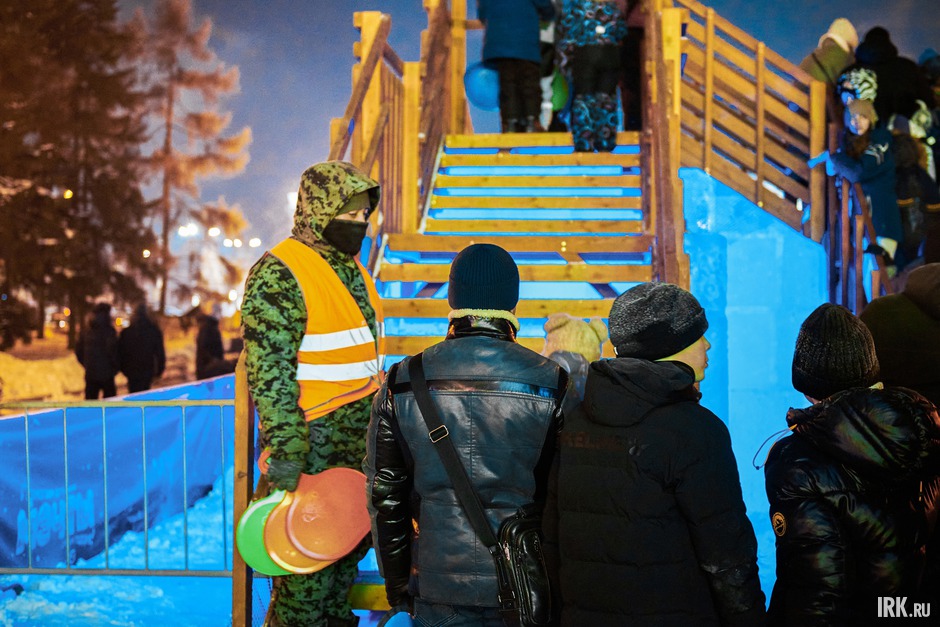 У лестницы на горку дежурят волонтёры, которые контролируют поток желающих покататься.