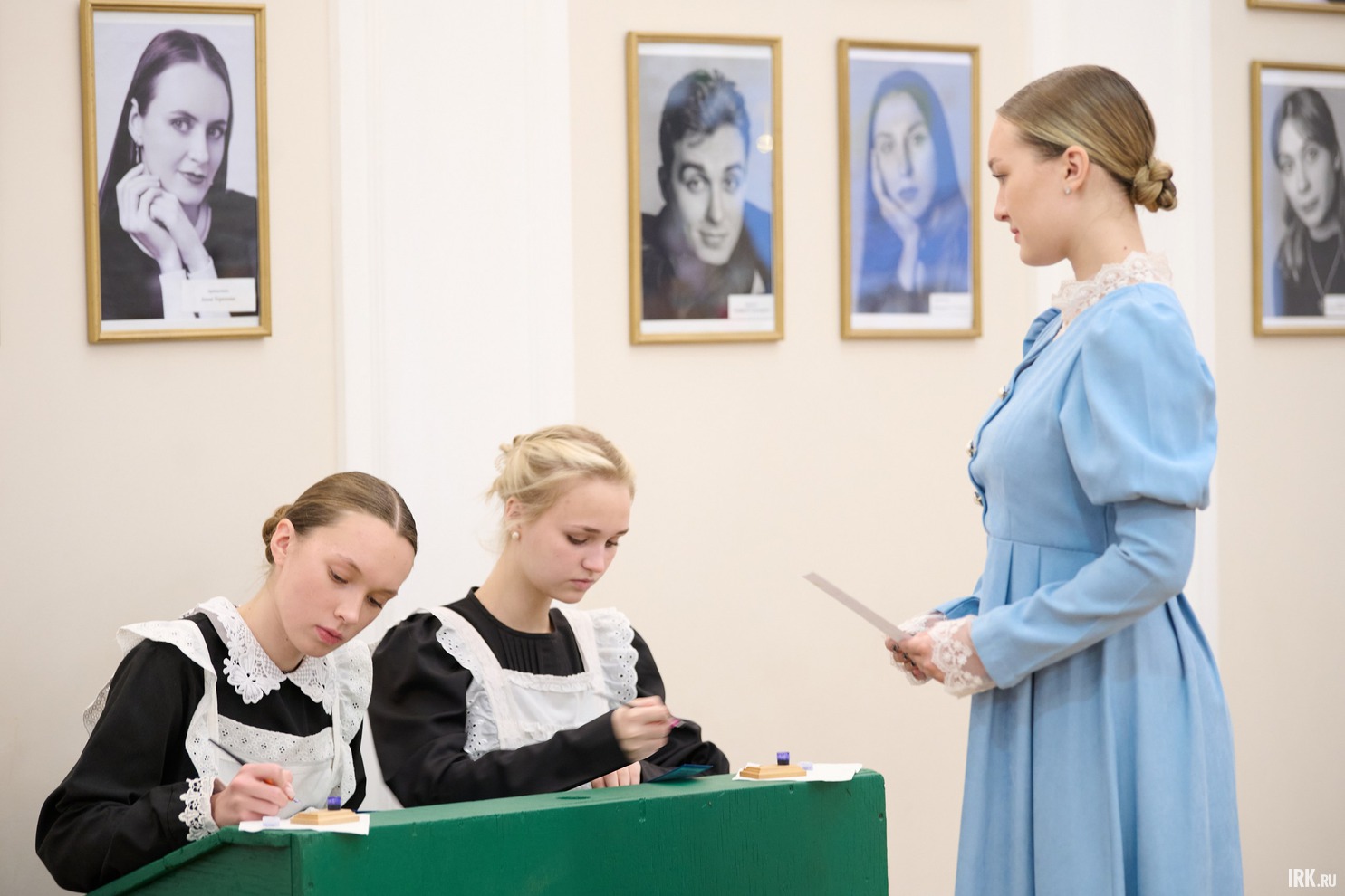 За старинной партой, используя перьевые ручки, под руководством старшеклассниц в образах гимназисток и учительниц начала XX века, гости писали поздравительные открытки.