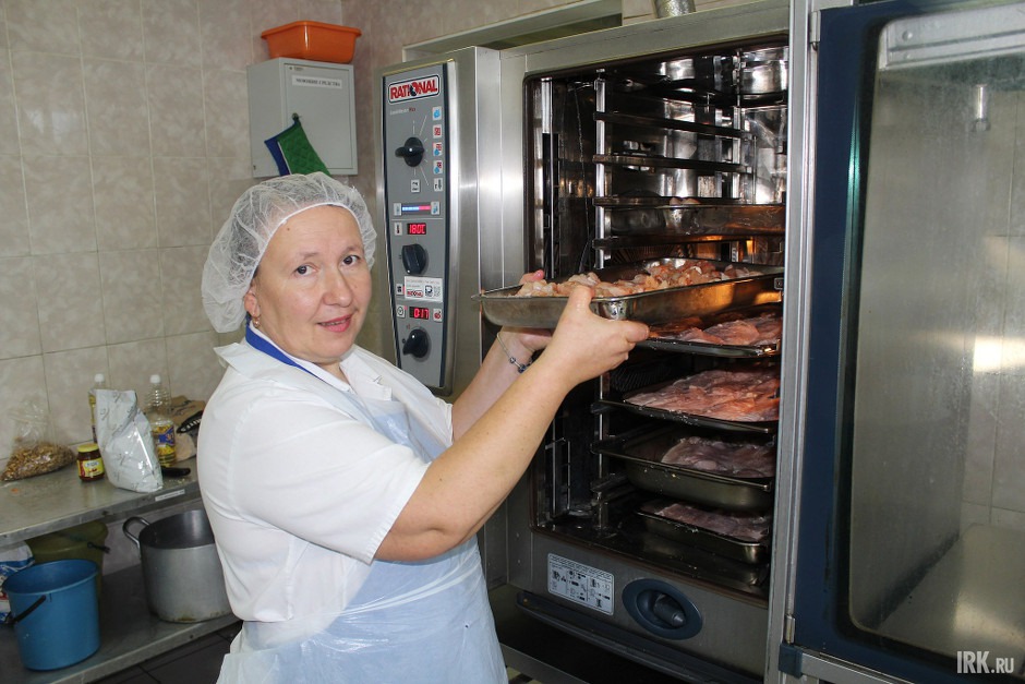 Повар Светлана Владимировна Назарова ставит противень в пароконвектомат. Фото Ольги Спиряевой