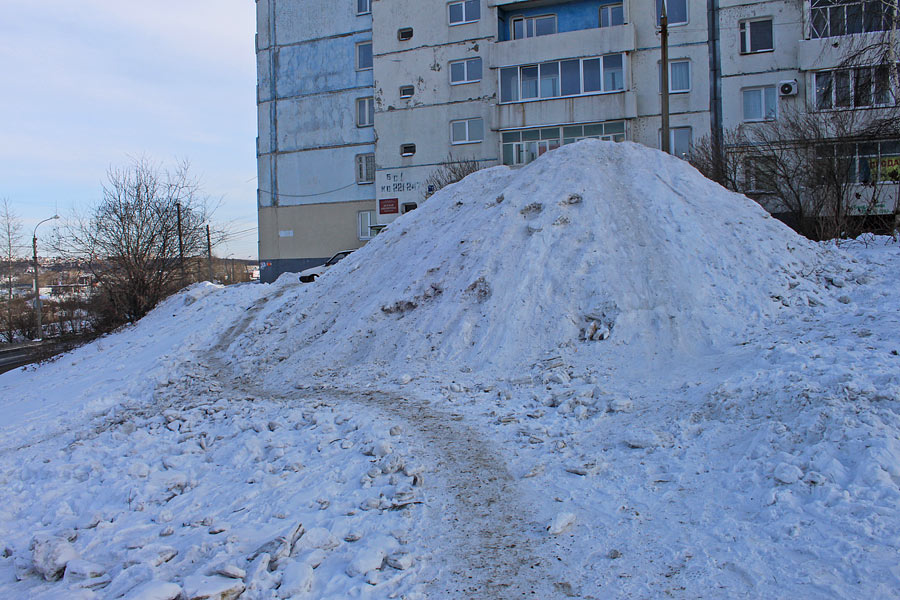Иркутянин: "Эту гору снега высотой более 3 метров высыпали прямо на пешеходную дорожку, по которой ежедневно сотни людей ходят в свои гаражи в АГК № 16. Образовавшийся скользкий обход могут преодолеть далеко не все. Напротив дома № 21а на бульваре Рябиков