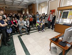 Гости выставки смотрят один из экспонатов выставки - мультфильмы, снятые молодыми авторами-иркутянами.